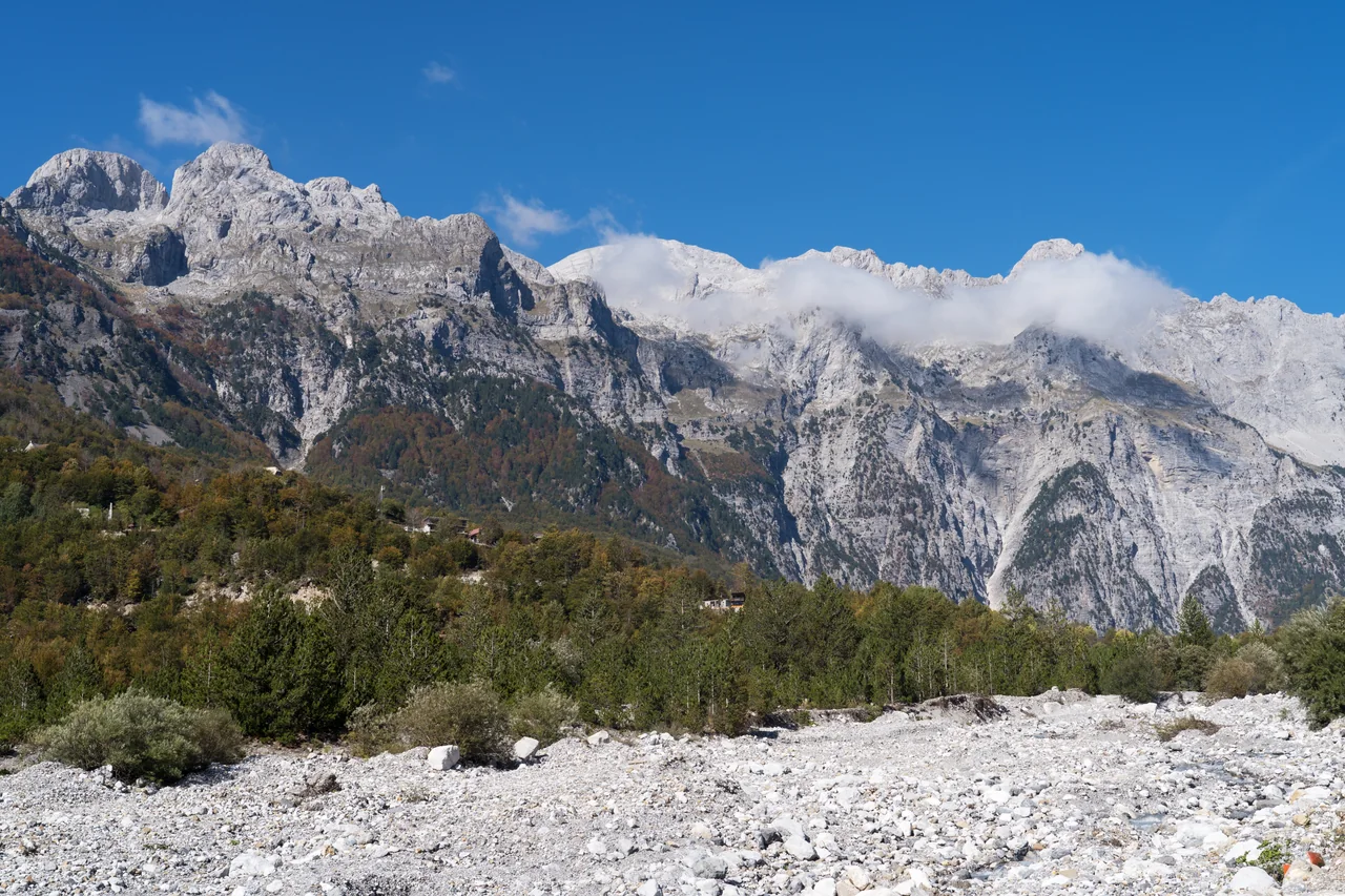 Limestone peaks rising above autumn woodland in Theth, in the Albanian Alps