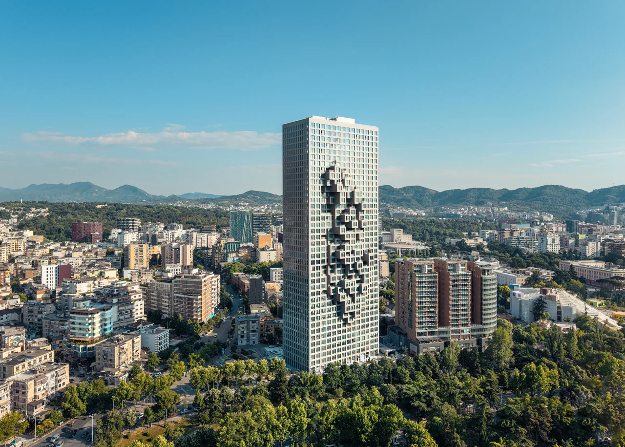 Contemporary towers and the urban landscape of Tirana, with mountains in the distance