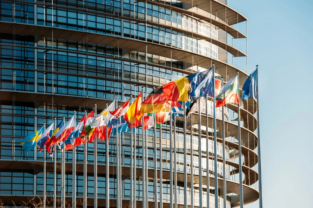European flags outside a modern glass-fronted institutional building