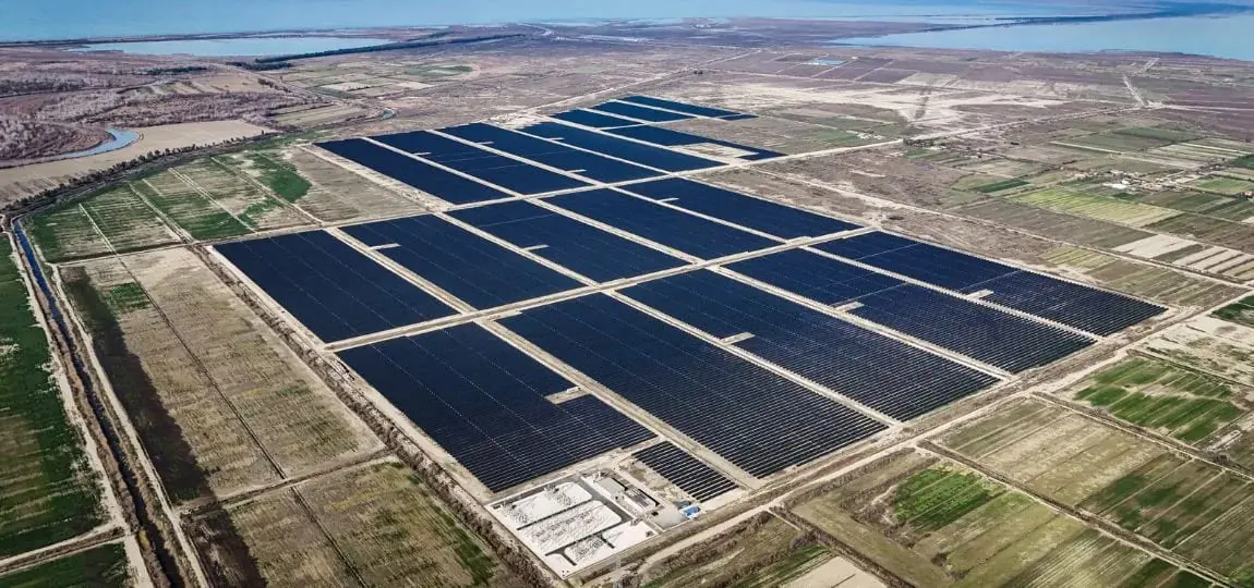 Aerial view of a large solar farm with rows of photovoltaic panels